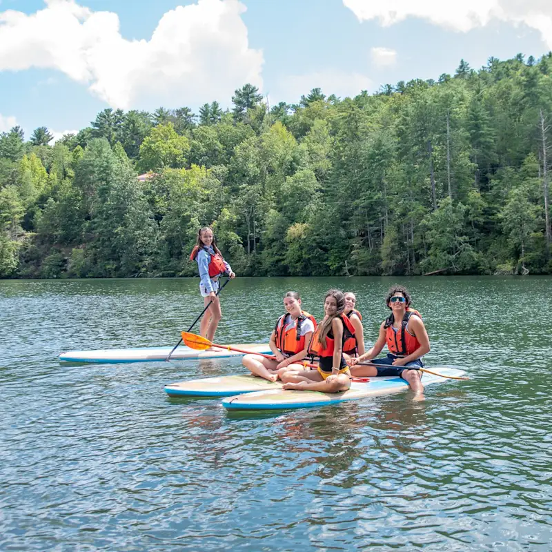 Alunos em stand up paddle no lago